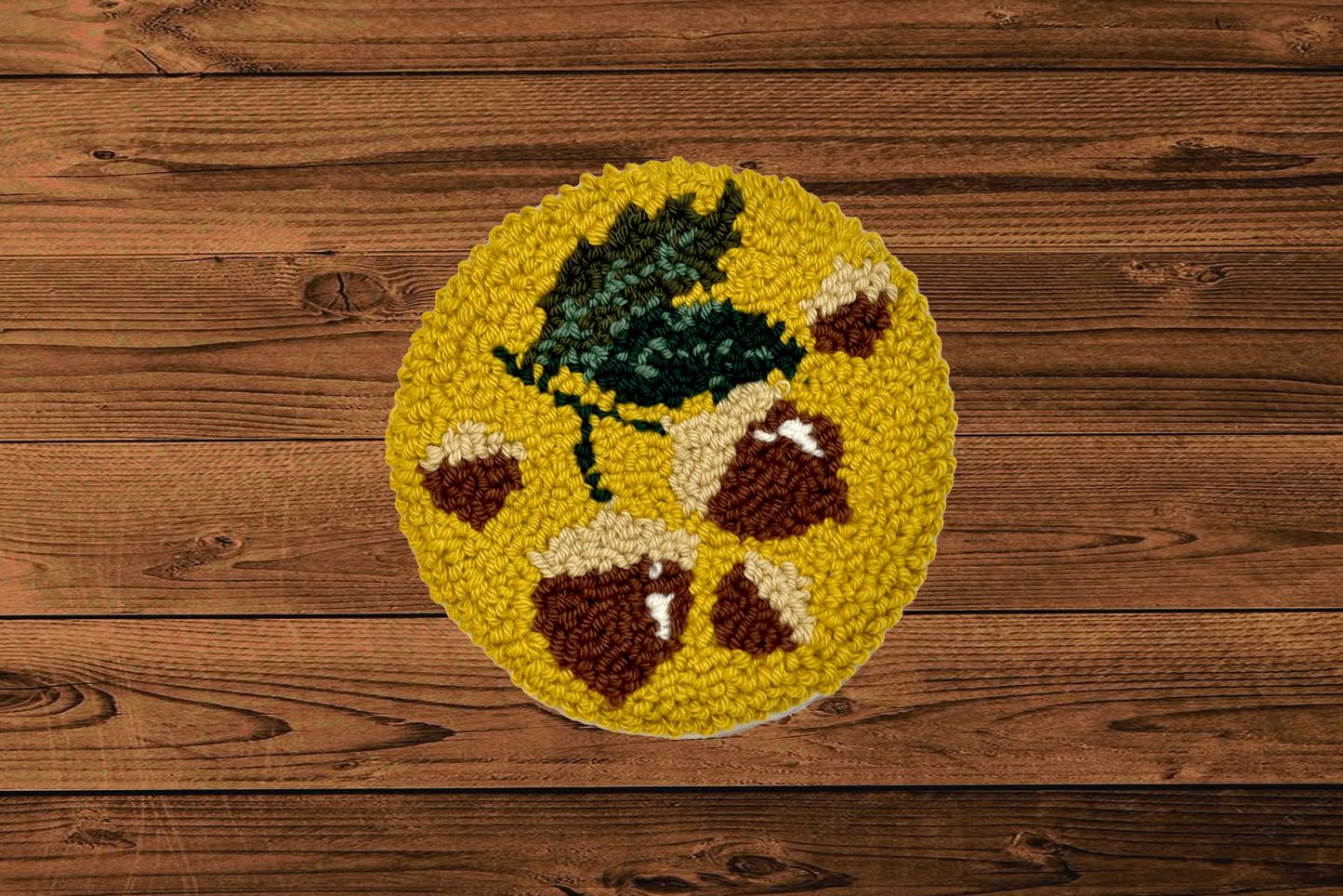Round yellow mug rug with brown and green  hazelnut design on a wooden floor