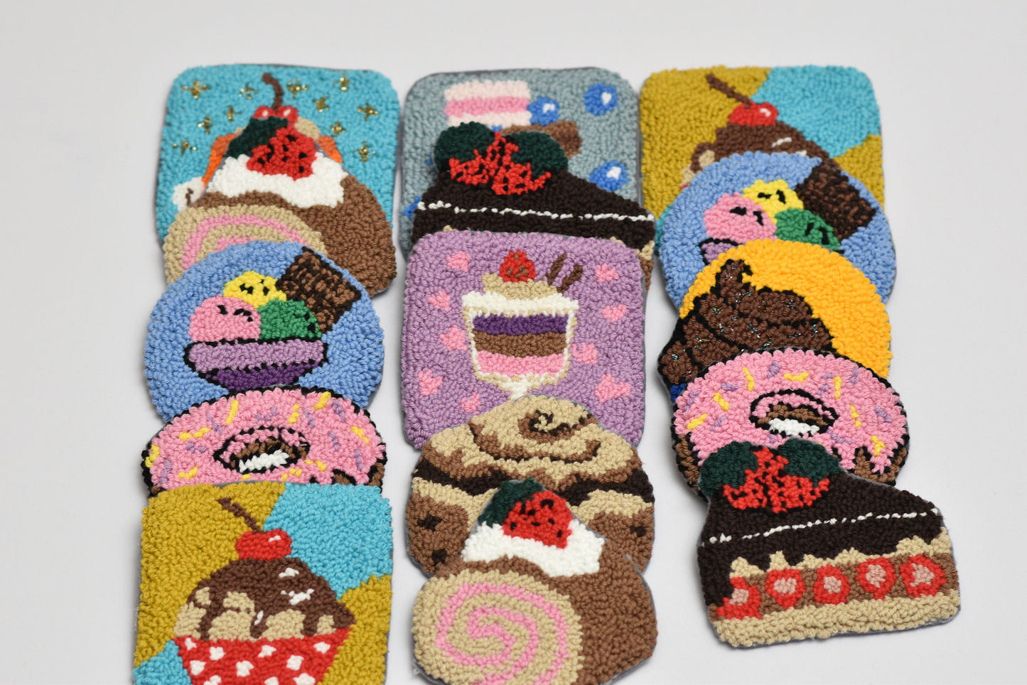 Set of colorful coasters with cake designs on a white background