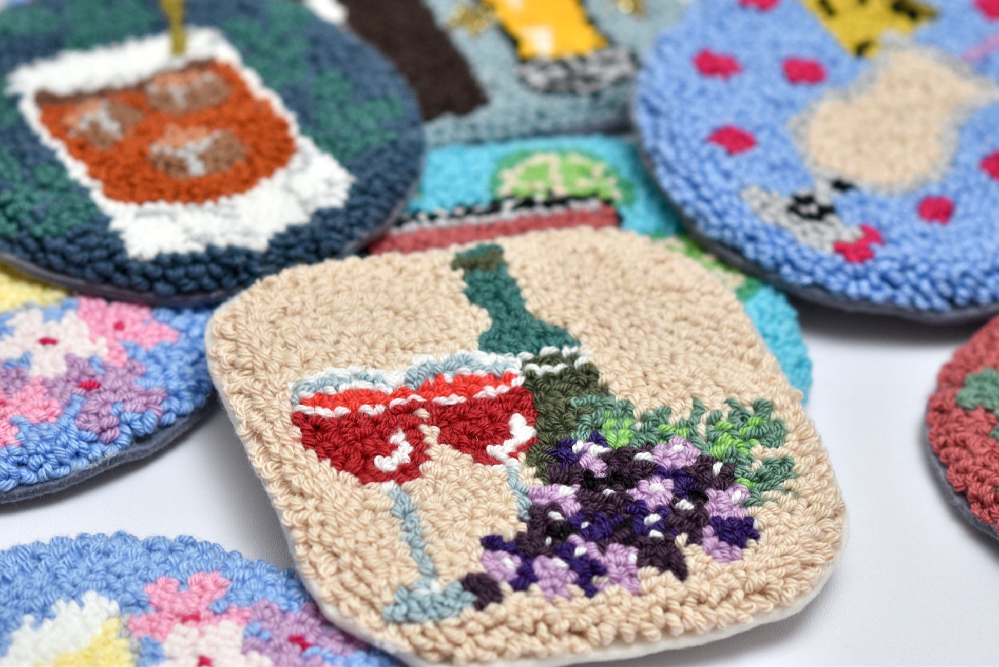 Collection of colorful embroidered coasters on a white surface