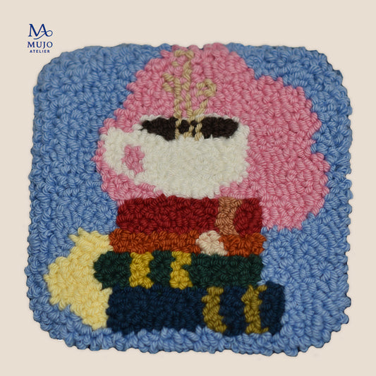 Punch needle pattern featuring a white coffee cup resting on a colorful stack of books, with a soft pink backdrop, blue background, and yellow accent.