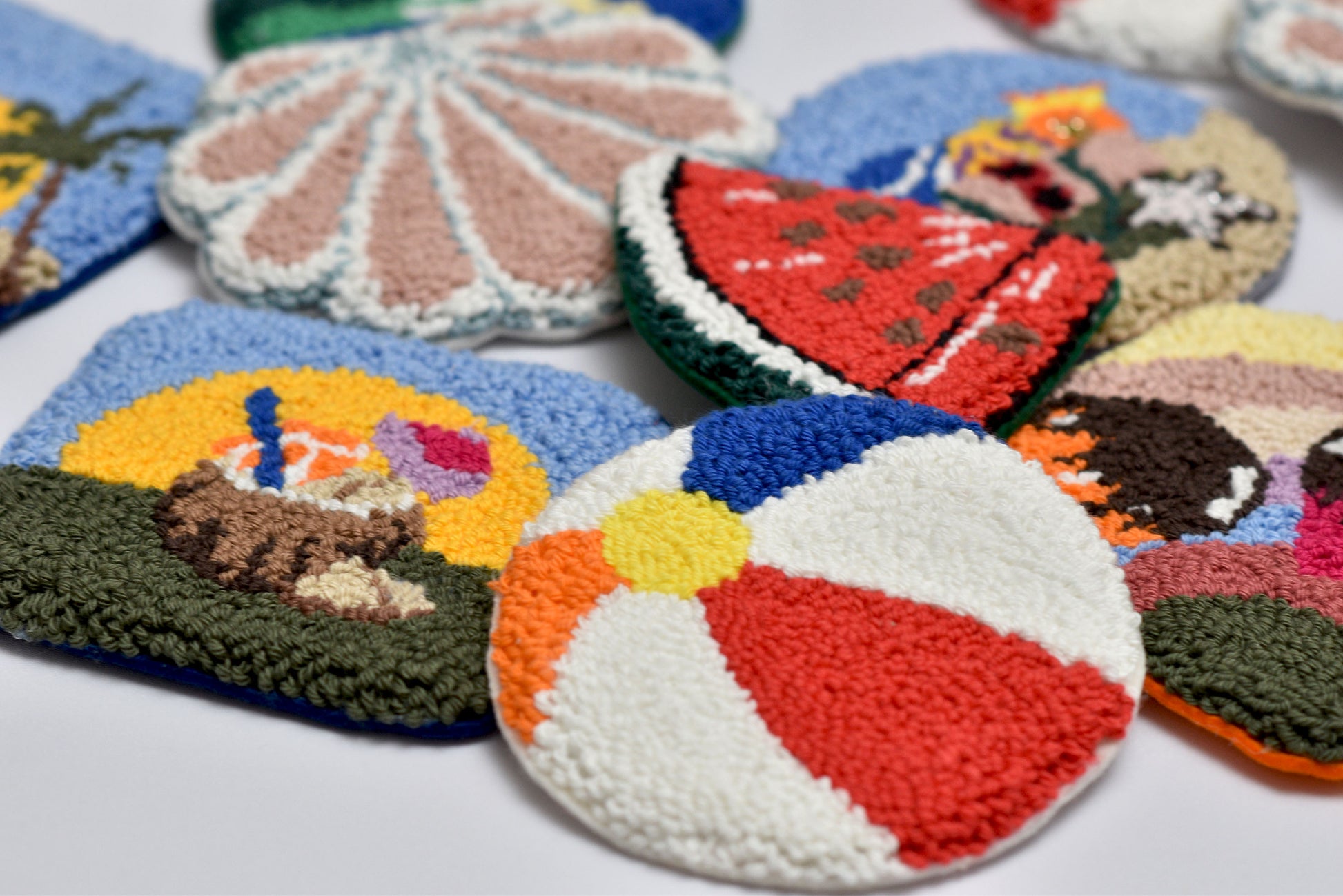 Colorful knitted coasters with various designs on a white surface