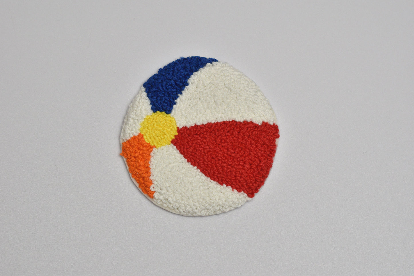Colorful round patch with blue, red, yellow, and orange sections on a gray background
