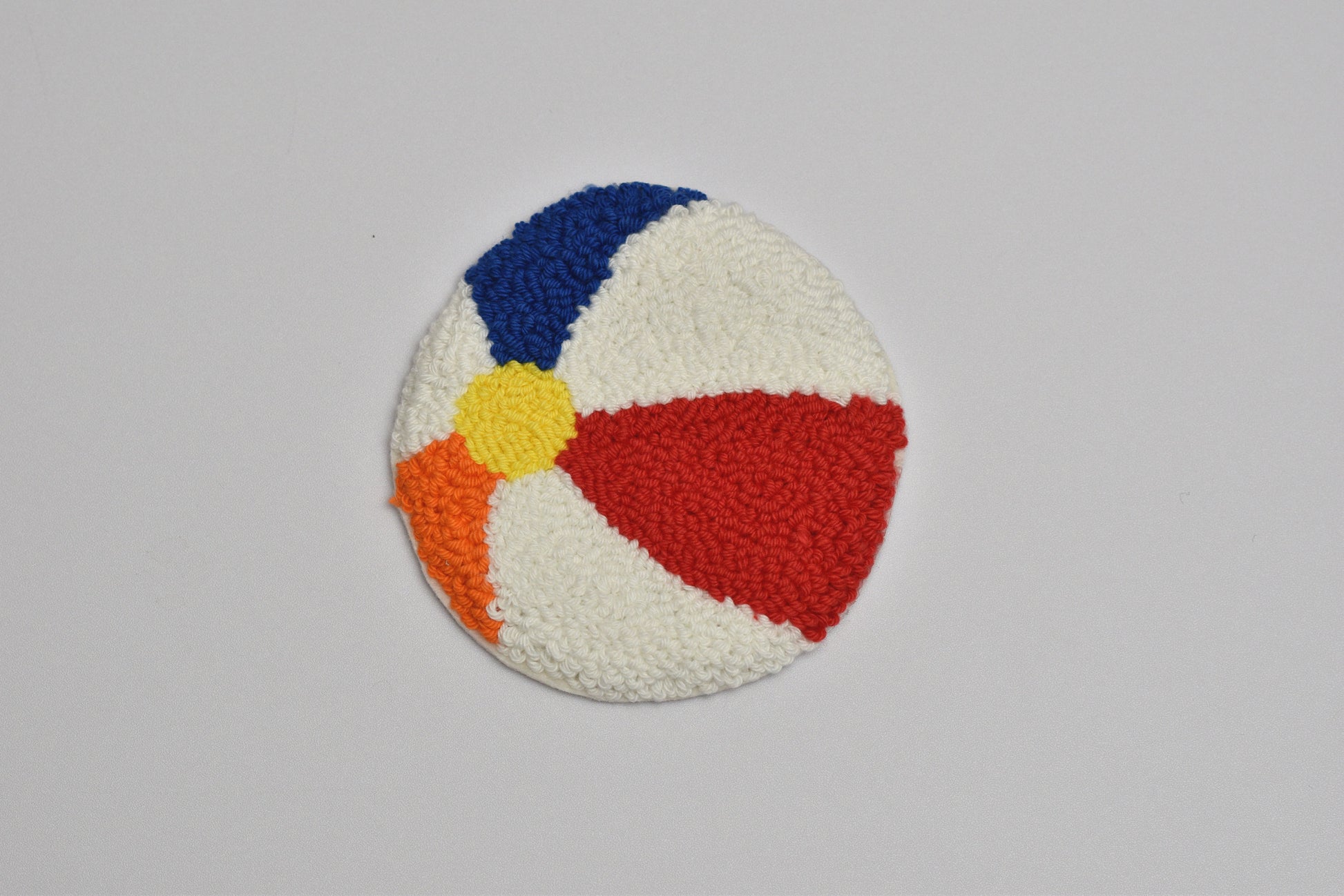 Colorful round patch with blue, red, yellow, and orange sections on a gray background