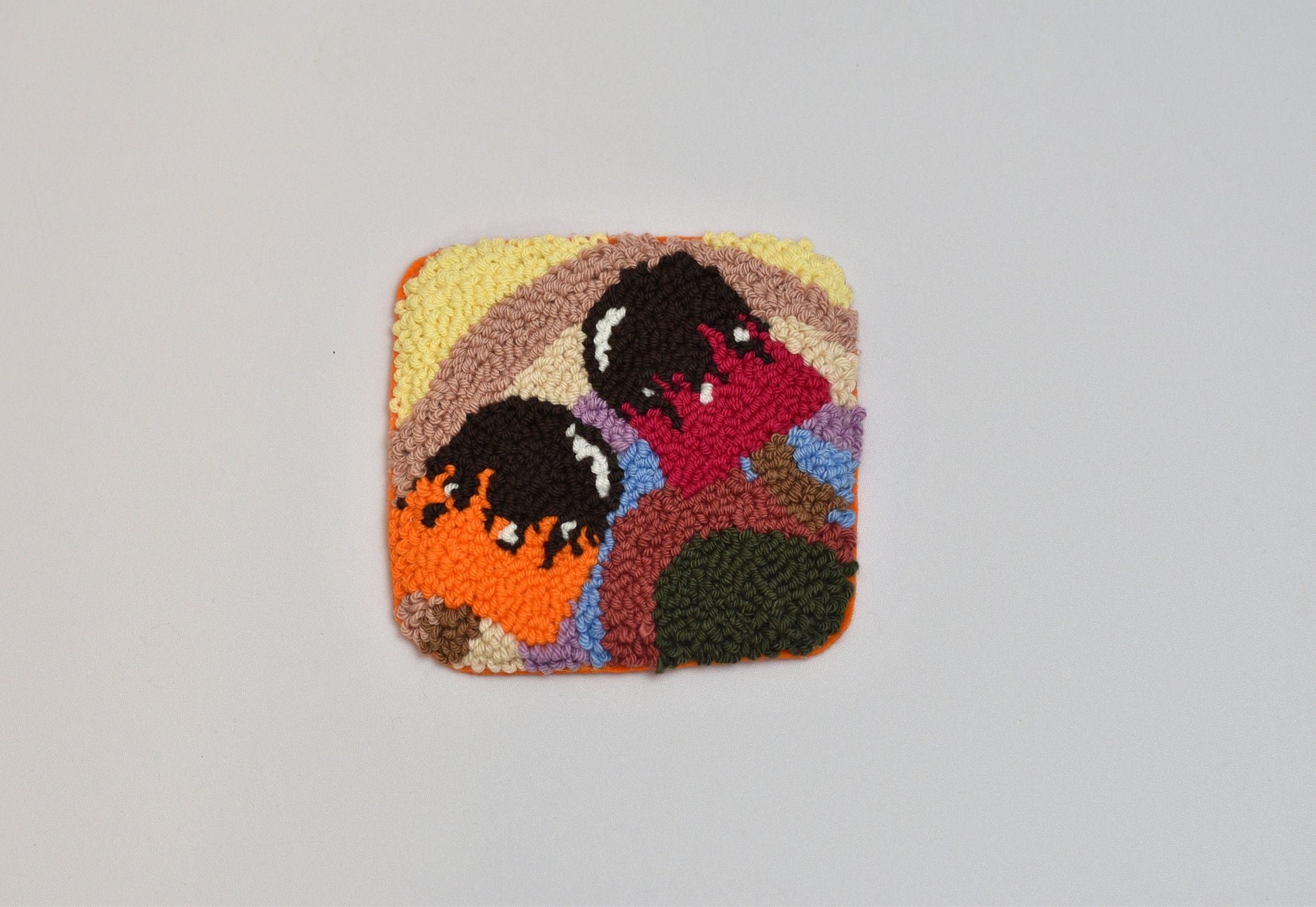 Square patch with embroidered design of two popsicles on a gray background