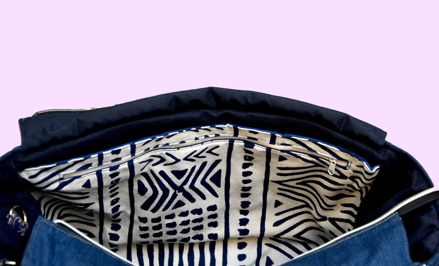 Interior of Navy bag with a patterned lining on a light purple background