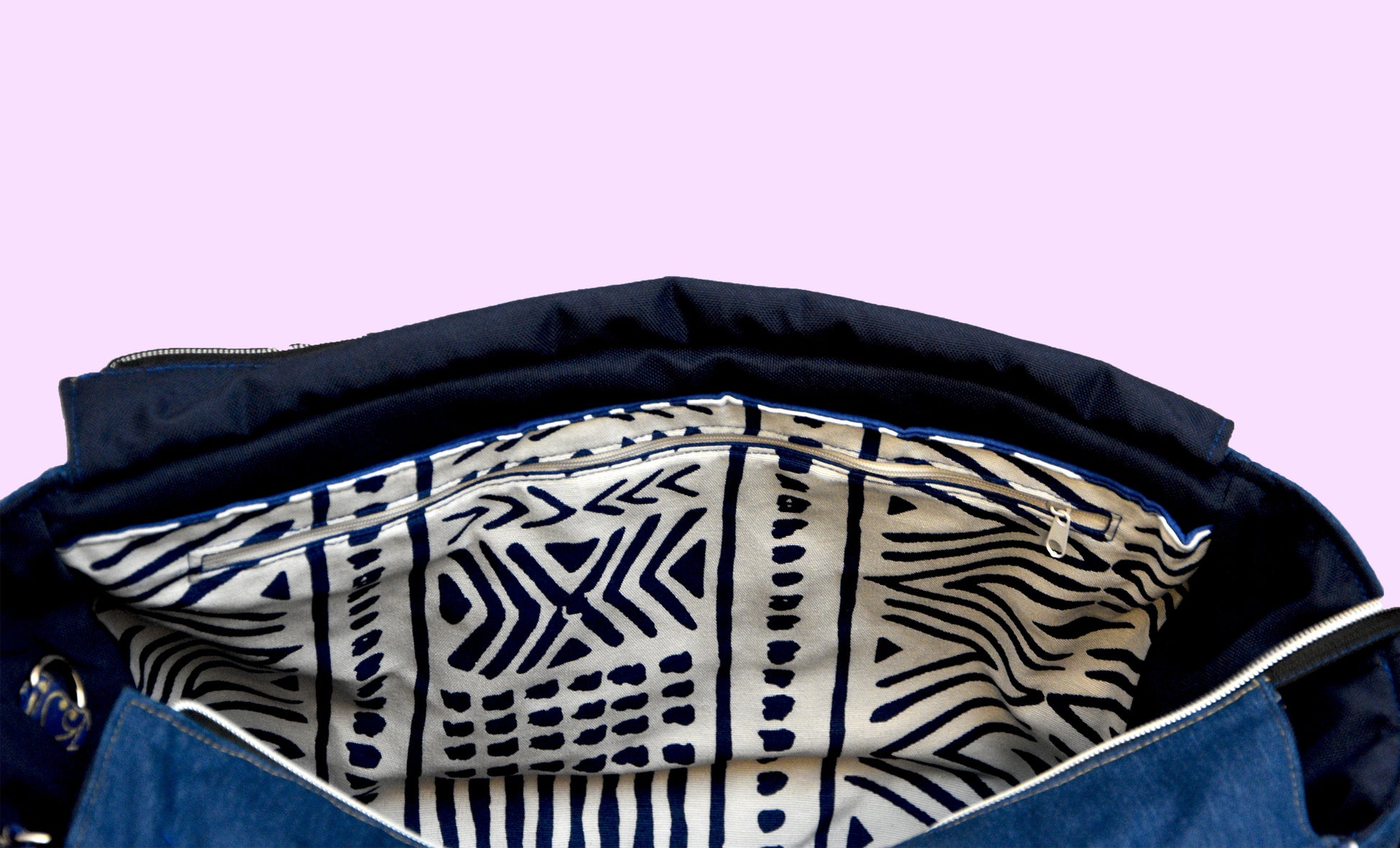 Interior of Navy bag with a patterned lining on a light purple background
