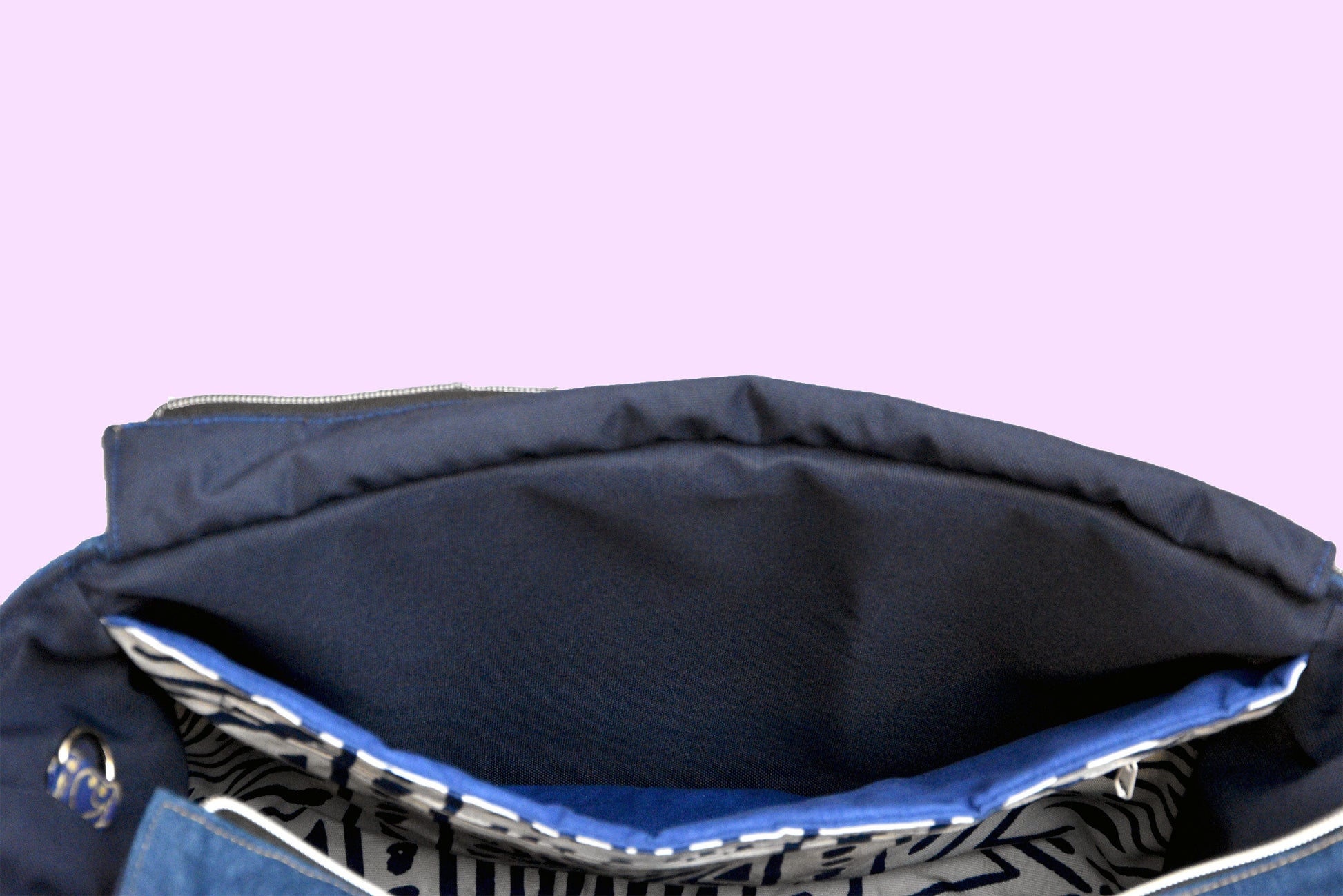 Navy blue bag with a patterned interior on a purple background