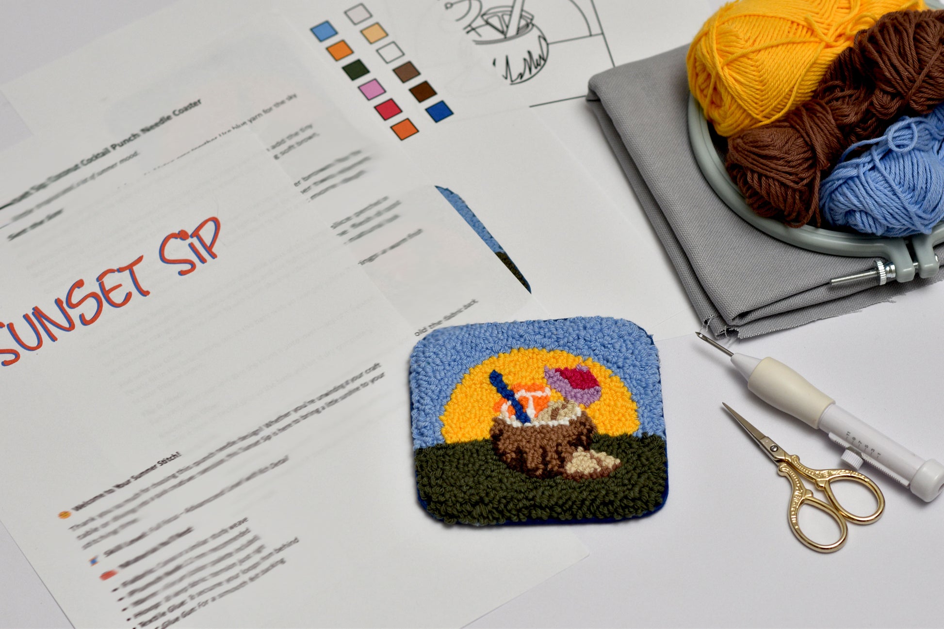 Handmade pouch with sunset design on a table with yarn and knitting tools.