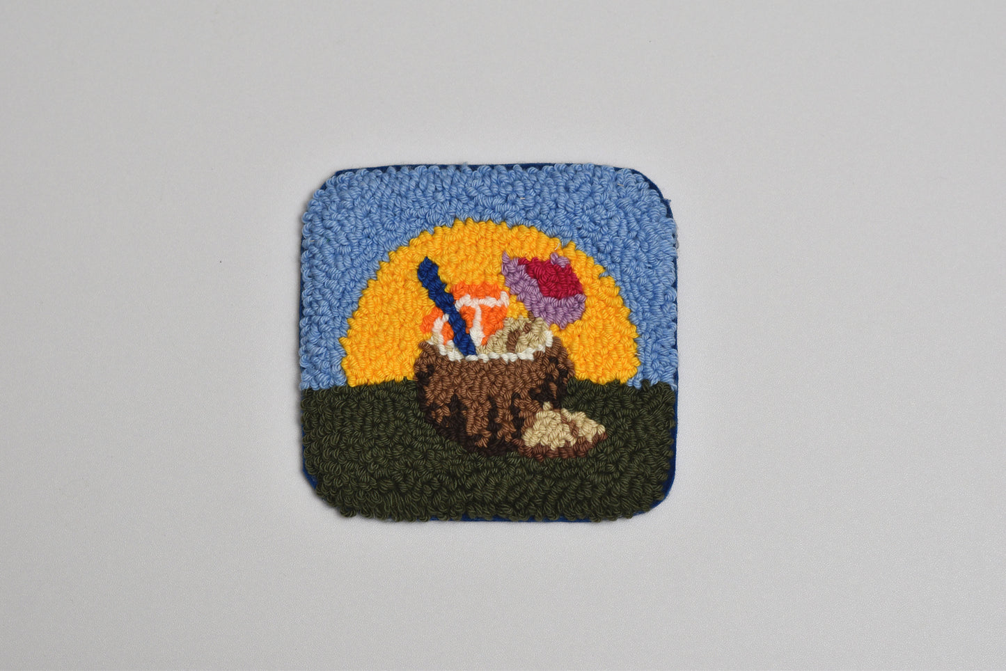 Decorative patch with a coconut and umbrella against a sunset background on a gray background