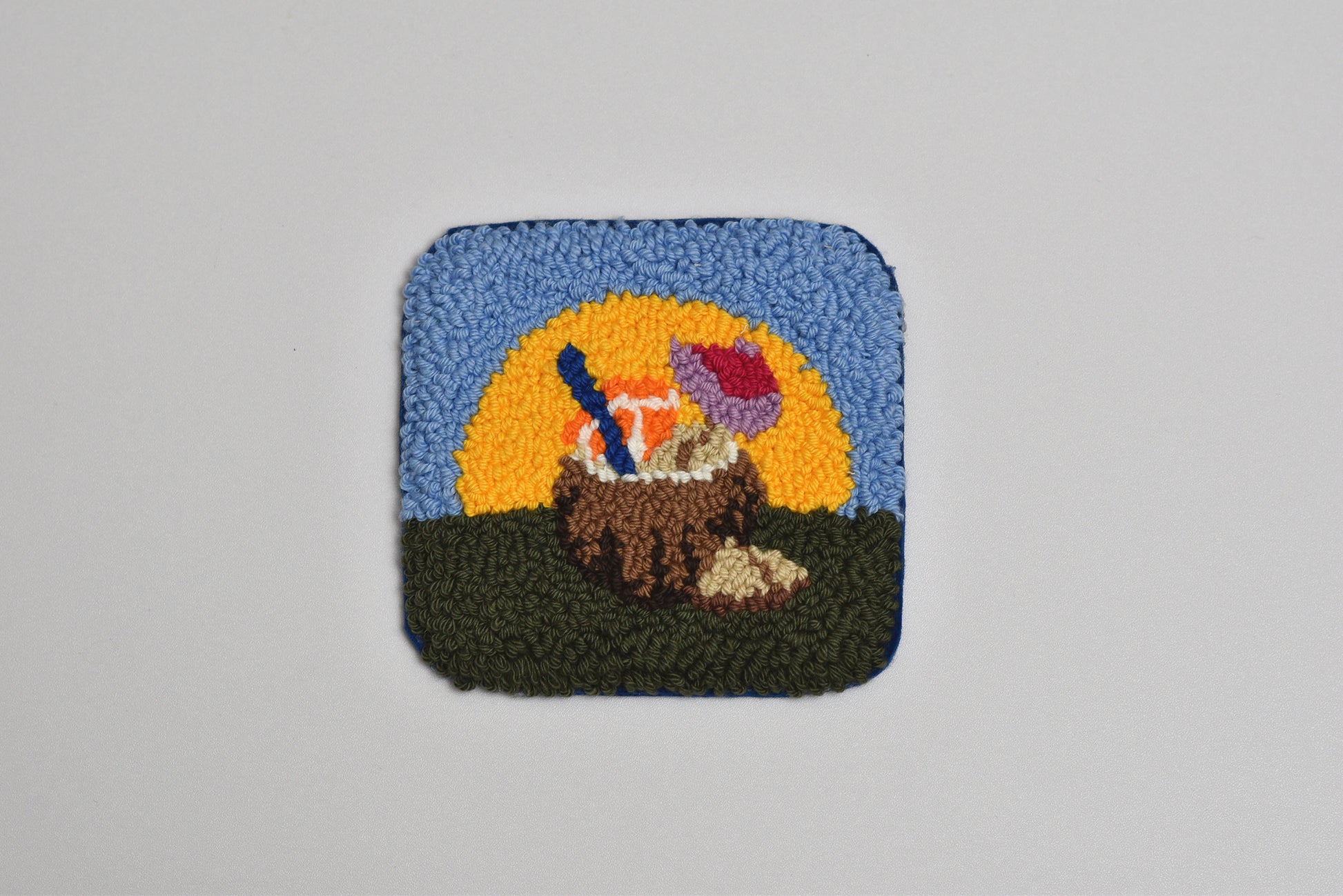 Decorative patch with a coconut and umbrella against a sunset background on a gray background