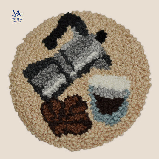 Round punch needle pattern featuring a classic Italian moka pot, espresso cup and scattered coffee beans in grey, brown and cream yarn.