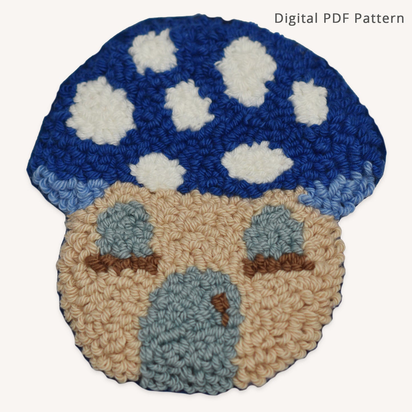 Blue mushroom house punch needle coaster pattern PDF featuring a whimsical cottage-style mushroom home with cloud-like white spots, pale blue windows, and a matching blue door. Beginner-friendly digital punch needle pattern with printable template and instant download.