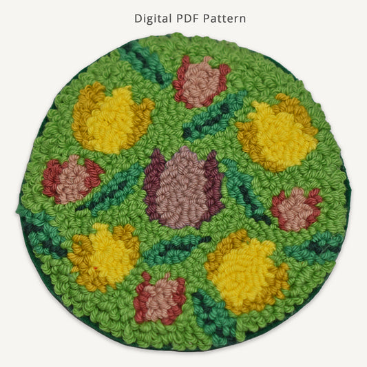 Floral tulip punch needle coaster digital PDF pattern featuring yellow and pink tulips on a green background, handmade spring-inspired punch needle design for DIY crafting.