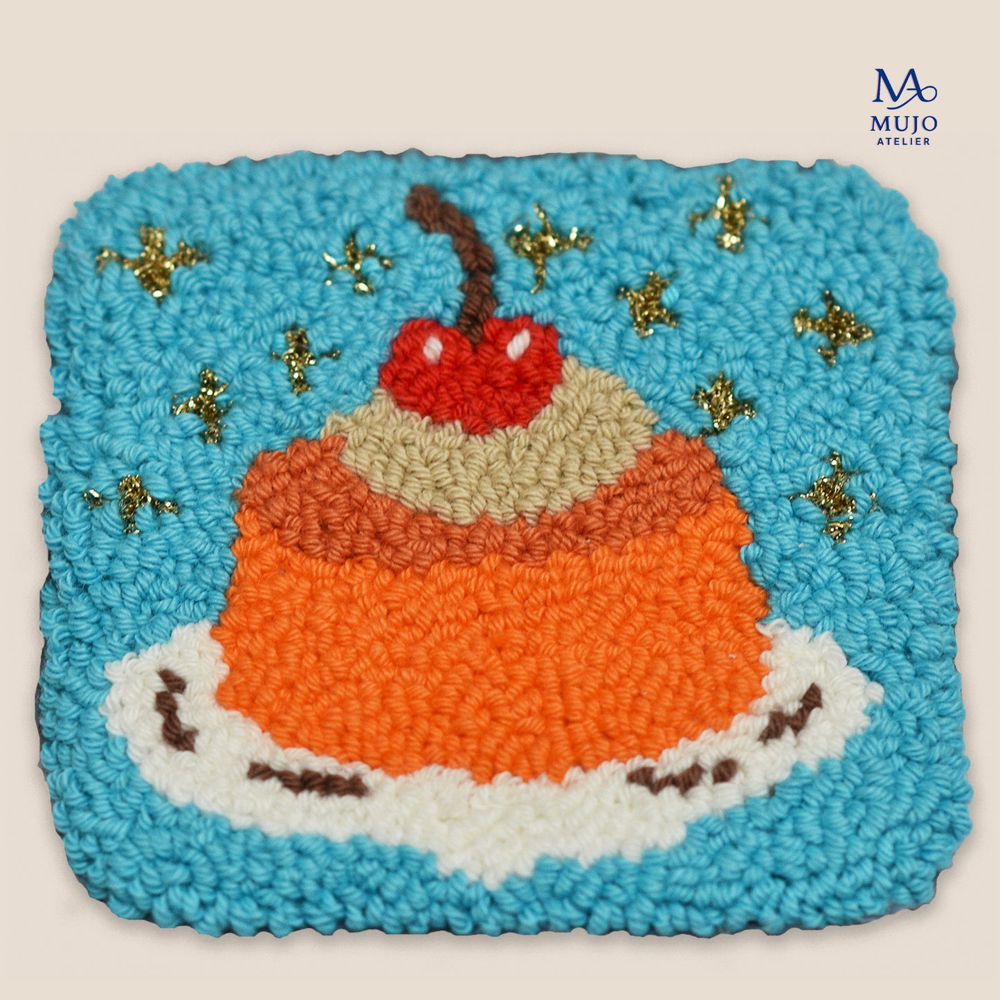 Punch needle jelly dessert coaster pattern with whipped cream, cherry and sparkling stars on a blue background. Digital PDF embroidery pattern by Mujo Atelier.