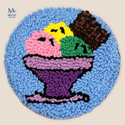 Punch needle ice cream sundae coaster pattern featuring colorful scoops of pink, yellow, green, purple, and chocolate ice cream in a purple dessert bowl on a blue background. Digital PDF embroidery pattern by Mujo Atelier.