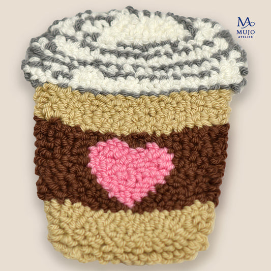 Punch needle coffee cup coaster pattern with pink heart sleeve, digital PDF embroidery design for beginners on a neutral background.