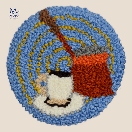 Round punch needle pattern featuring a traditional Turkish coffee cezve, small coffee cup and yellow fortune-telling swirls on a blue background.