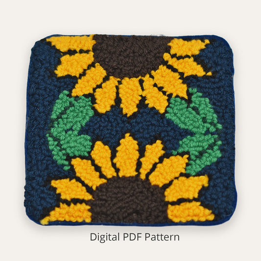 Punch needle sunflower coaster pattern featuring bold yellow sunflowers on a deep navy blue background, handmade textured embroidery design shown as a finished square coaster, digital PDF pattern for beginners