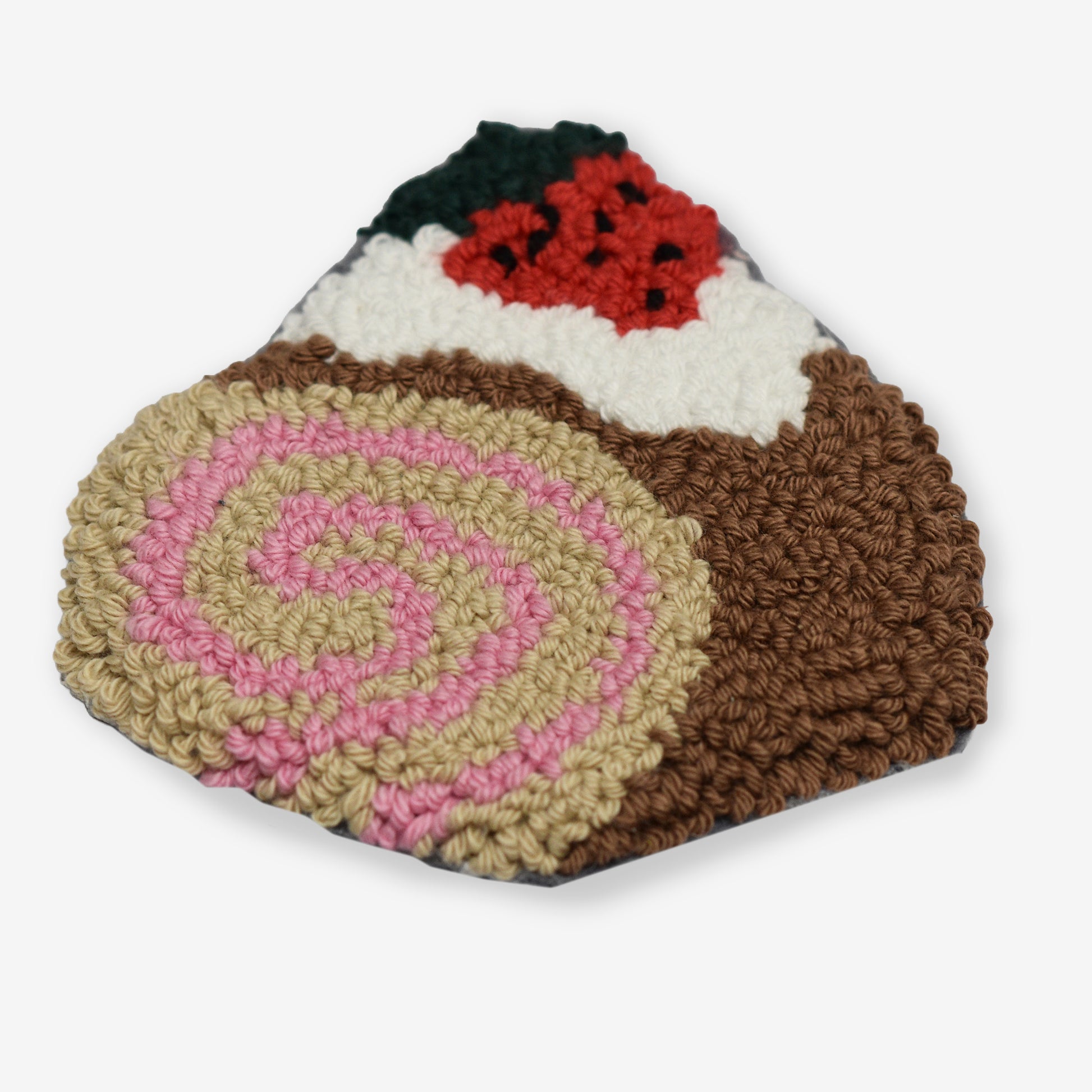 Handmade strawberry roll cake punch needle coaster, punch needle embroidery with pink swirl, cream filling, and strawberry detail, shown on a clean light background