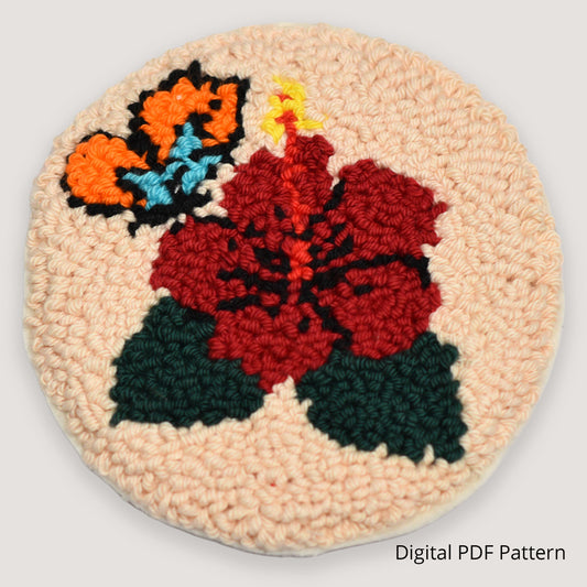 Handmade punch needle coaster featuring a red hibiscus flower with butterfly detail, looped embroidery texture on a neutral beige background, digital PDF punch needle pattern.