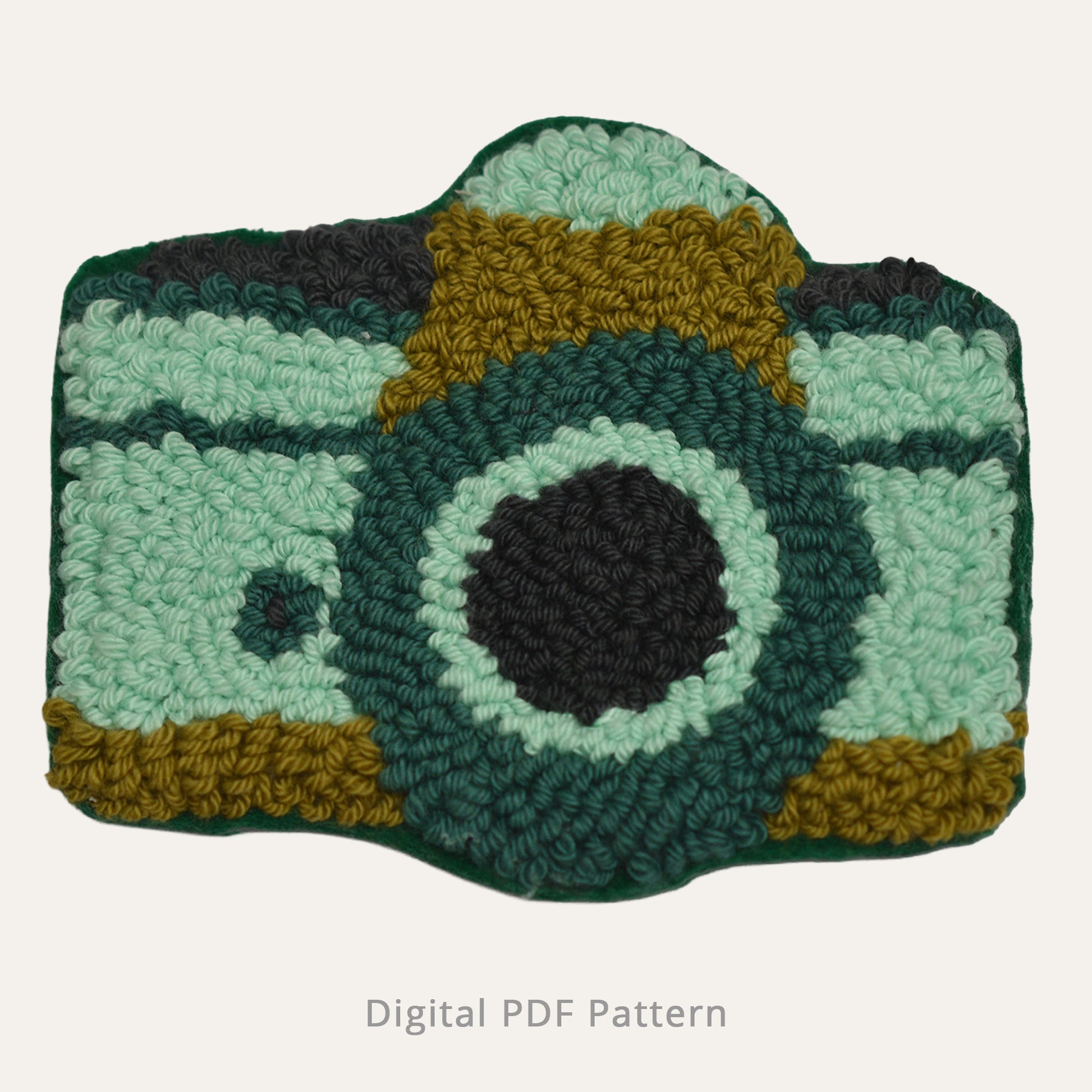 Punch needle camera motif in soft mint, deep green, and warm mustard tones, shown as a textured handmade design on a neutral background. Digital PDF punch needle pattern with clear loop detail and modern retro color palette.