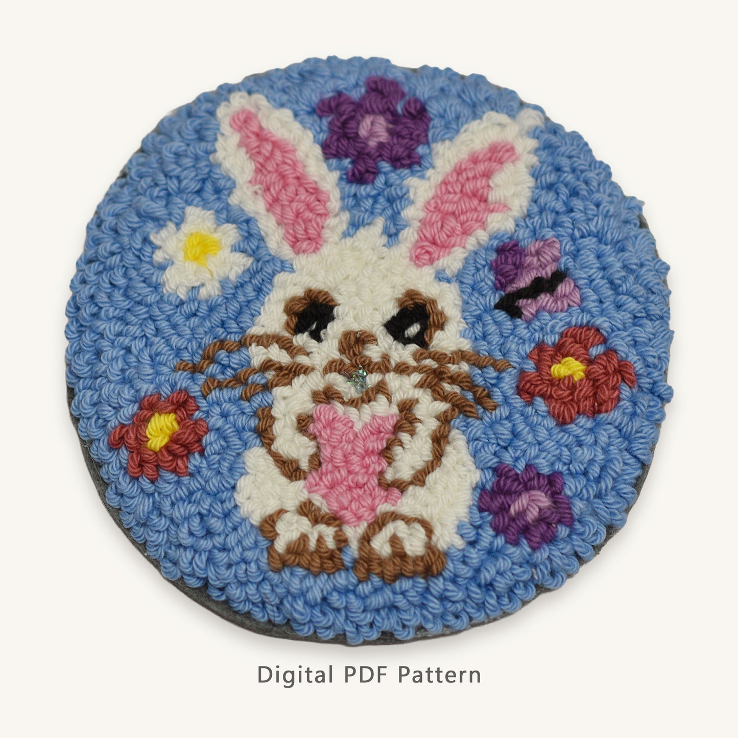 Round bunny punch needle pattern design with white rabbit and pink ears on blue floral background, digital PDF rug hooking pattern.