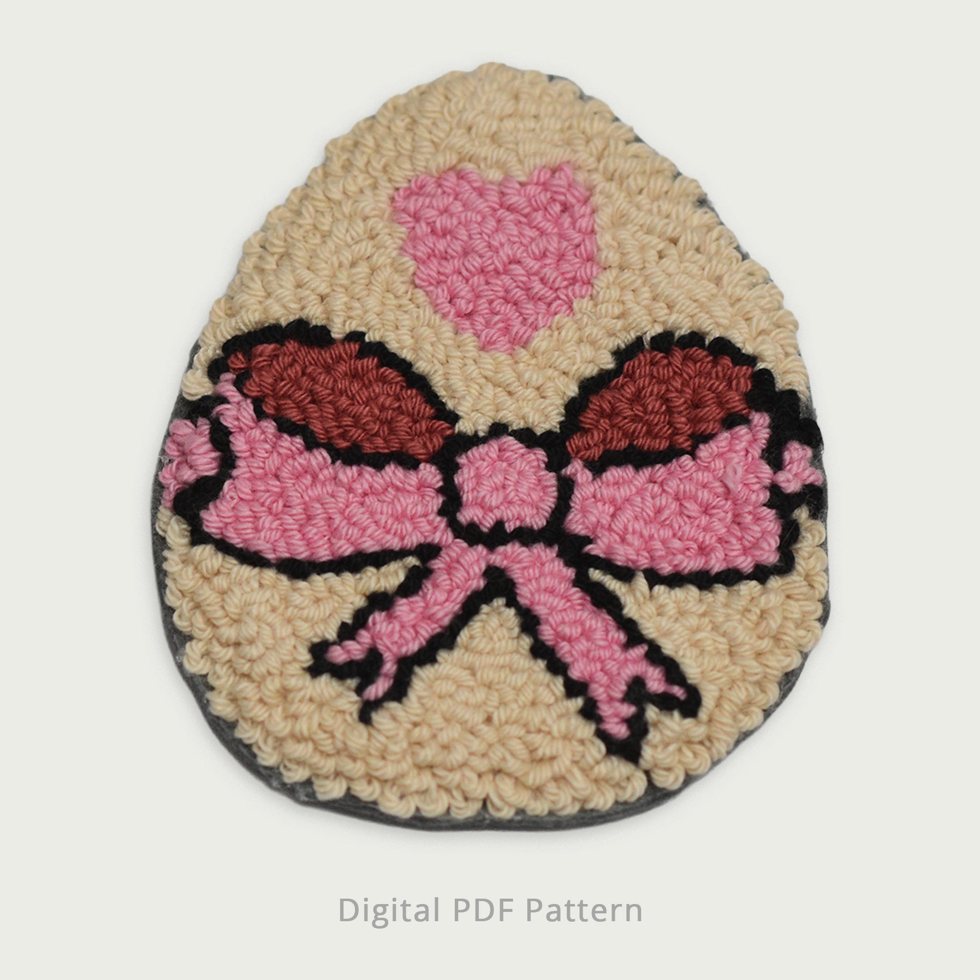 Punch needle Easter egg coaster featuring a pink bow and heart motif, textured handmade look, digital PDF punch needle pattern